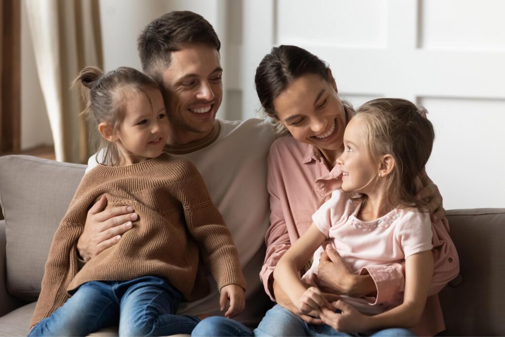 happy couple with daughters on couch