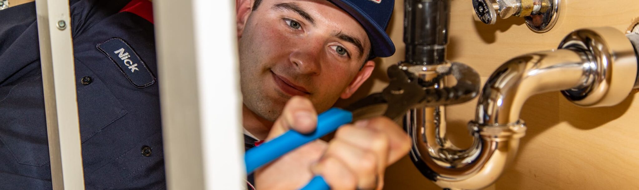 Goettl technician fixing piping under the sink