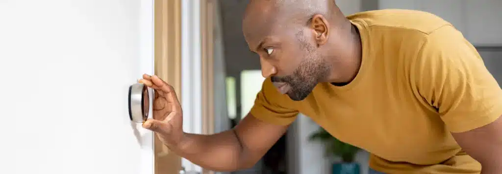 Man adjusting thermostat