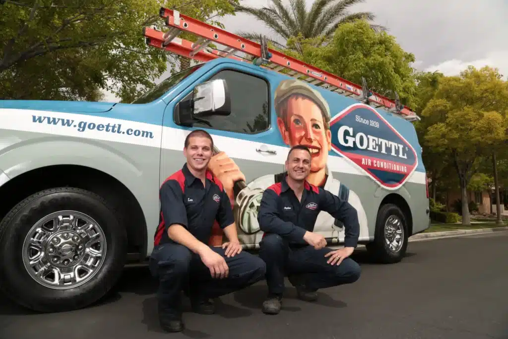 two goettl technicians posing in front of goettl van