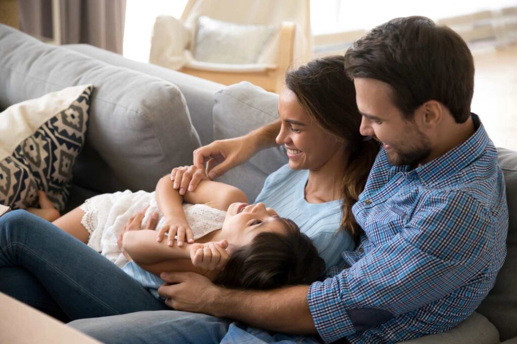 happy couple with daughter on couch