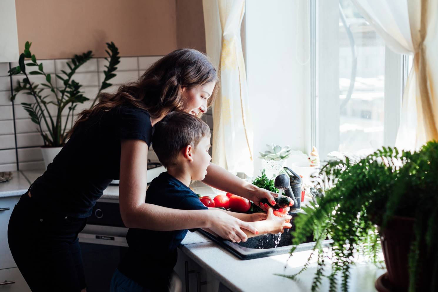 A mother and son using a sink