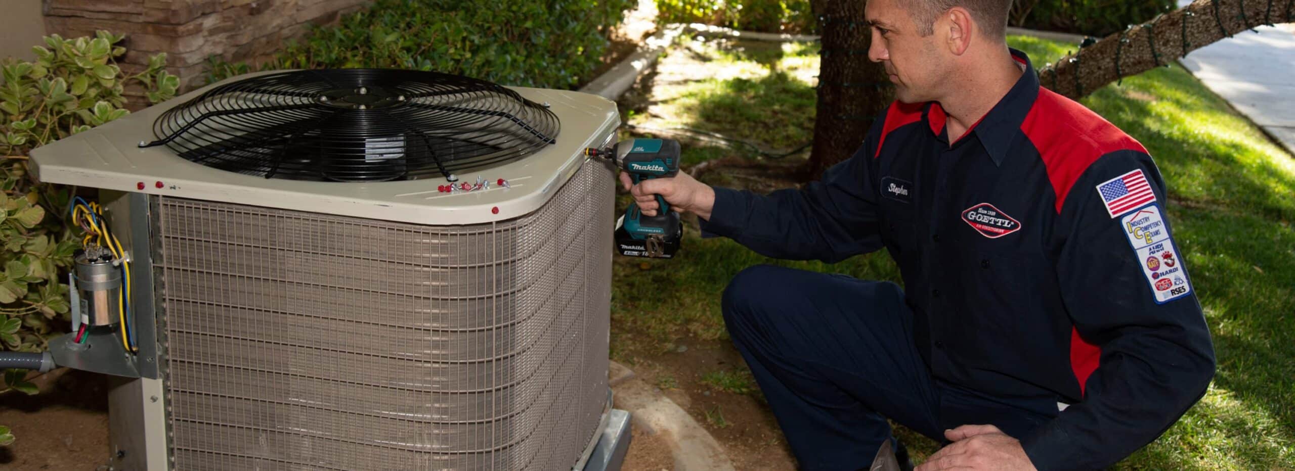 Goettl technician replacing screws on Air conditioning unit