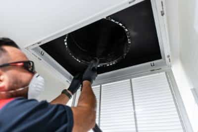 Goettl technician cleaning a duct