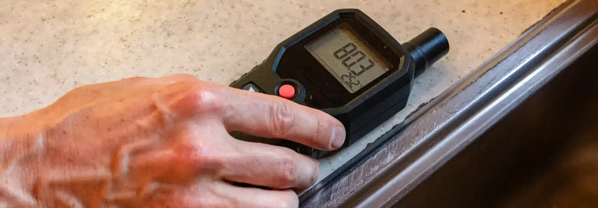 Person testing indoor air quality with special device