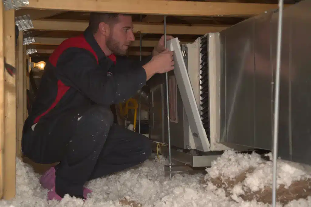 Male Goettl technician in attic replacing heating vent