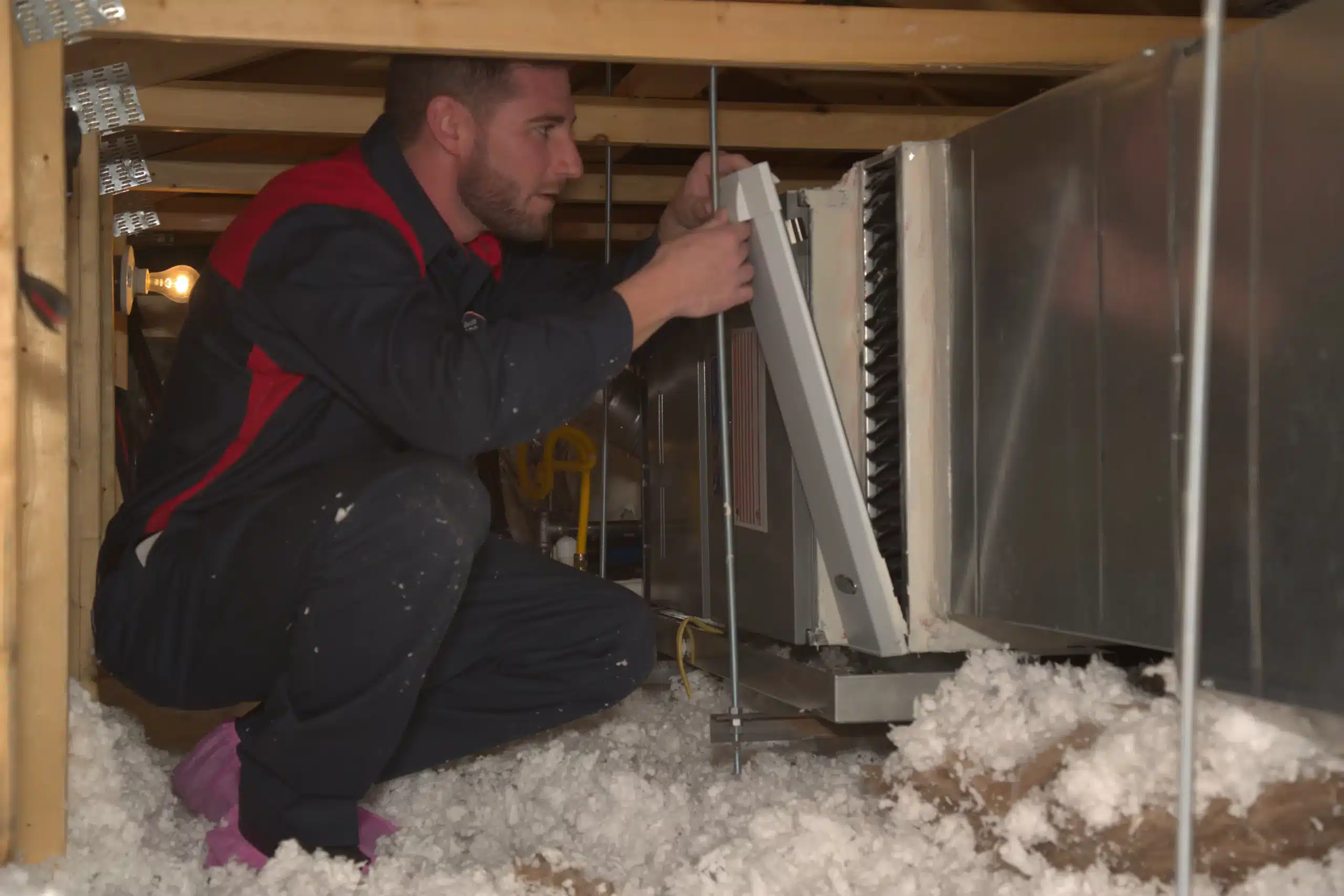 Male Goettl technician in attic replacing heating vent