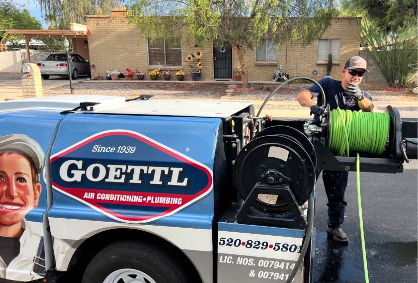 goettl plumbing technician unrolling trenchless sewer repair tubing from back of truck