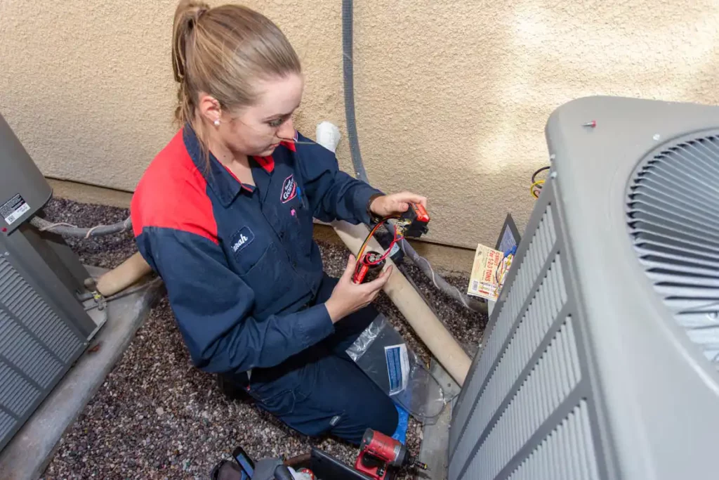 Goettl technician fixing outdoor air conditioning unit