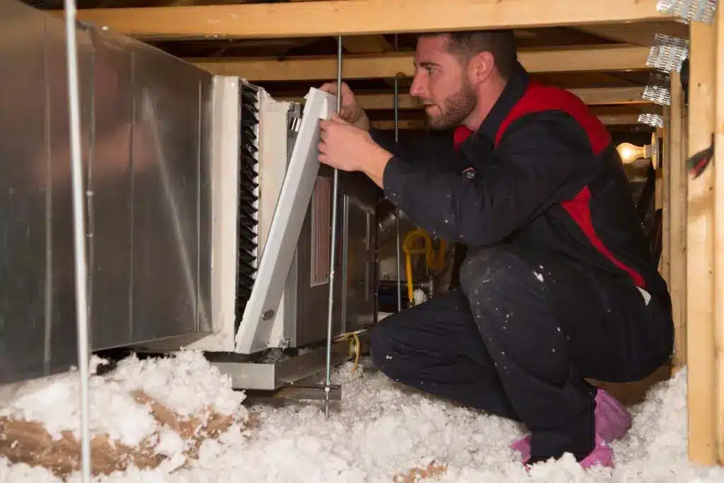 Goettl technician working on heating system in attic
